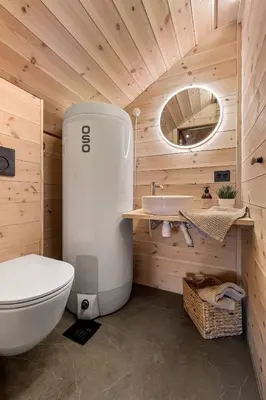 a bathroom with a white toilet and a sink at Skarhaug Panorama Lodge in Stranda
