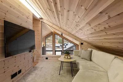 a living room with a couch and a flat screen tv at Skarhaug Panorama Lodge in Stranda