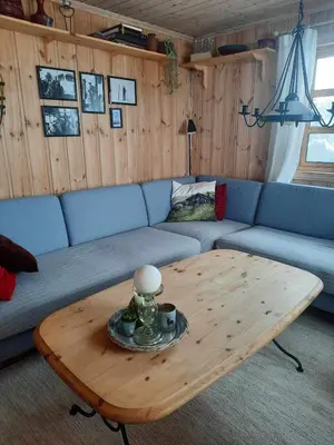 a living room with a blue couch and a coffee table at Familiehytte på Botn, Vågslid til leie in Botn