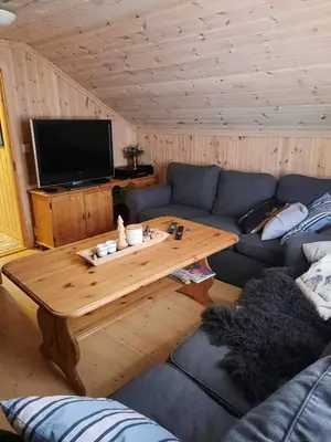 a living room with a blue couch and a wooden table at Familiehytte på Botn, Vågslid til leie in Botn
