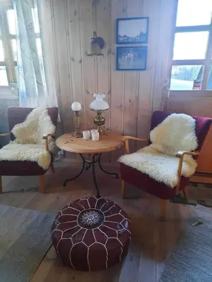 a living room with two chairs and a table at Familiehytte på Botn, Vågslid til leie in Botn