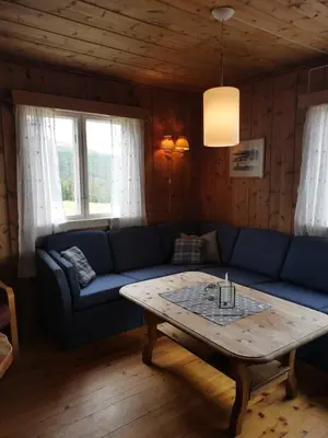 a living room with a blue couch and a coffee table at Åsrud seter i Jotunheimen in Randsverk