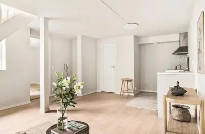 a white living room with a vase of flowers on a table at Lev livet i Bergen - Stor moderne leilighet in Bergen