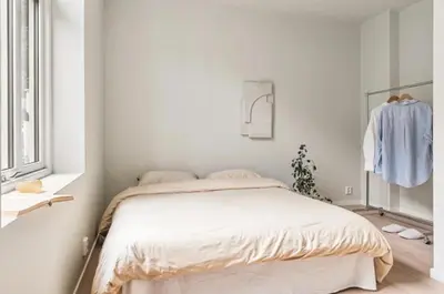 a white bedroom with a bed and a window at Lev livet i Bergen - Stor moderne leilighet in Bergen