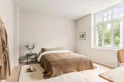 a white bedroom with a bed and a window at Lev livet i Bergen - Stor moderne leilighet in Bergen