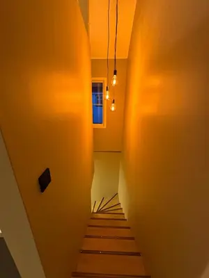 a hallway with a stairway leading up to a window at Sandvik's stuen in Bergen