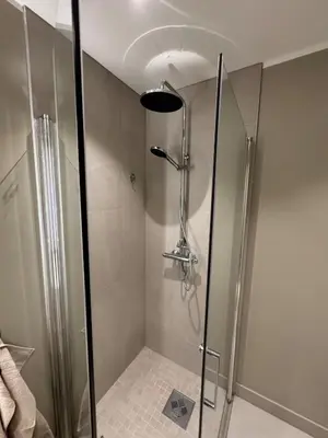 a shower with a glass door in a bathroom at Sandvik's stuen in Bergen