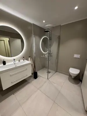 a bathroom with a shower and a sink and a toilet at Sandvik's stuen in Bergen