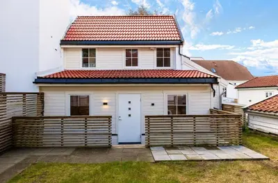 a white house with a red roof at Sandvik's stuen in Bergen
