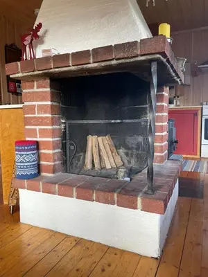 a brick oven with a pile of wood in it at Nedre Flaata Seter in Nørdstebø