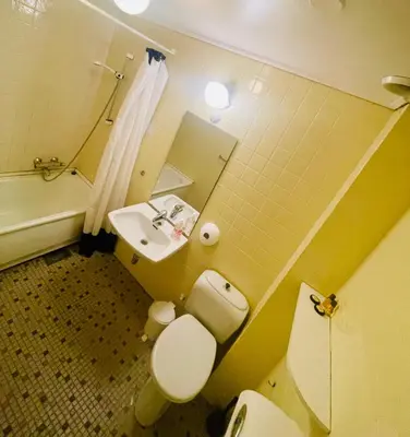 a bathroom with a toilet and a sink and a tub at Suldal Hotell in Sand