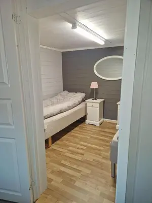 a small bedroom with a bed and a mirror at Cosy living room, bedroom and bathroom and kitchen area in Kolavåg