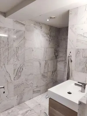 a bathroom with a white sink and marble walls at Central 2-Bedroom Apartment in Voss in Vossevangen