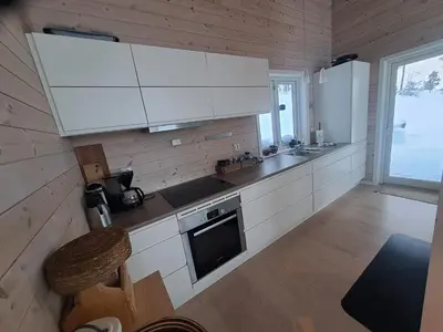 a kitchen with white cabinets and a stove top oven at Hytte Hummelfjell, Os in Os