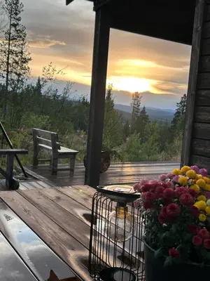 a deck with a bench and a basket of flowers at Hytte Hummelfjell, Os in Os