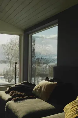 a bedroom with a large window and a couch with a view at Modern, spacious top apartment in Lii
