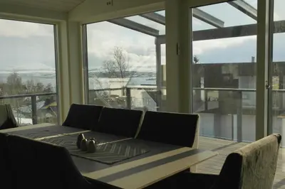 a living room with a table and a large window at Modern, spacious top apartment in Lii