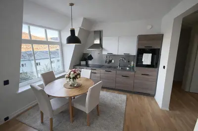 a kitchen with a table and chairs and a kitchen with a sink at central apartment in Bergen and pet friendly in Bergen