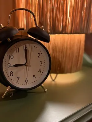 a clock sitting on a table next to a curtain at Musekroken in Elverum