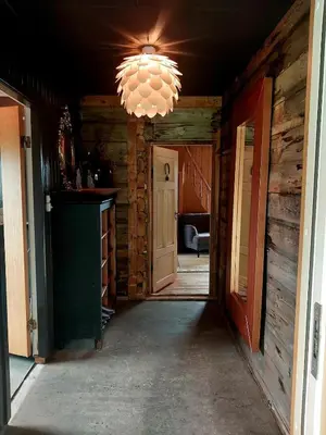 a hallway in a log cabin with a chandelier at Llama Lodge 8 beds 4 Bedrooms in Kleivane