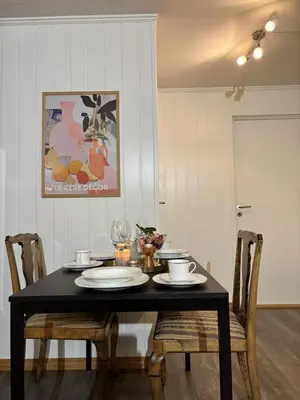 a dining room table with a black table and chairs at Moderne leilighet med 2 soverom for jobb og ferie in Raufoss