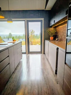 a kitchen with white cabinets and a large window at Modern cabin with jacuzzi near Trysil alpine in Trysil