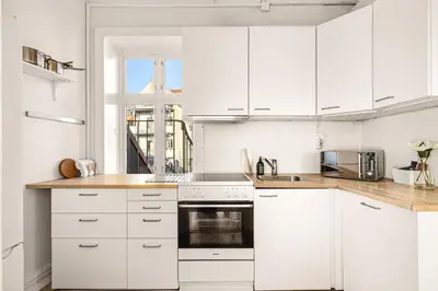 a white kitchen with white cabinets and a sink at City Center Apartment - Top location in Bergen