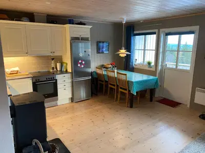 a kitchen with a table with a blue table cloth at Leilighet i Fageråsen, Trysil, med ski inn og ut in Trysil
