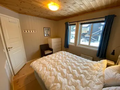 a bedroom with a large bed and a window at Leilighet i Fageråsen, Trysil, med ski inn og ut in Trysil
