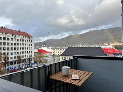 a wooden table on top of a balcony with a rainbow at Corner apartment with balcony in Bergen in Bergen