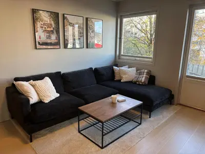 a living room with a black couch and a coffee table at Corner apartment with balcony in Bergen in Bergen