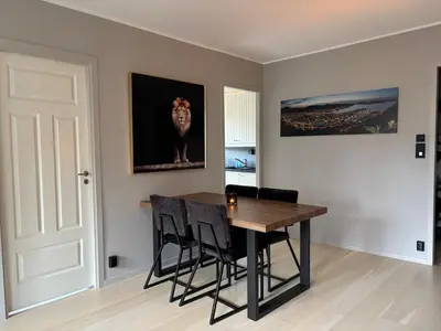 a dining room with a wooden table and black chairs at Corner apartment with balcony in Bergen in Bergen