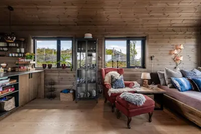 a living room with a red chair and a table at Lykka - lovely cabin with amazing view in Torpo