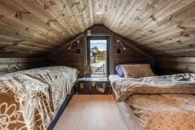 two beds in a room with a window at Lykka - lovely cabin with amazing view in Torpo