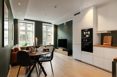 a kitchen and living room with a table and chairs at NEW! I Modern Comfort in the Heart of Bergen in Bergen
