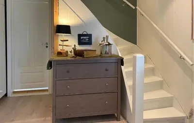 a chest of drawers in a hallway with stairs at Beach Front Home In Rovde With Wifi in Rovde