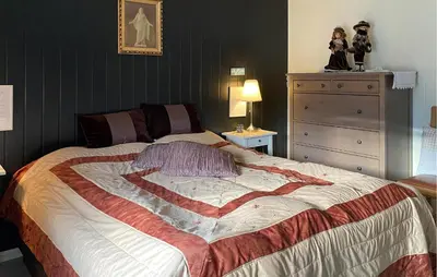 a bedroom with a bed with a heart quilt on it at Beach Front Home In Rovde With Wifi in Rovde