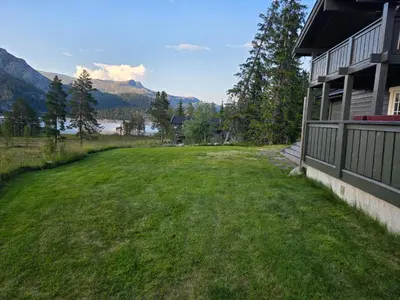 a yard next to a house with mountains in the background at Kilodden, Lakeside Mountain Cabin with Stunning Views in Tuddal