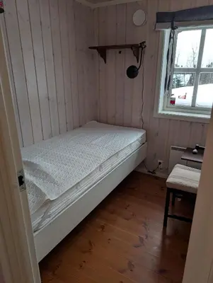 a small bedroom with a bed and a window at Håvi Solsiden 11C in Trysil