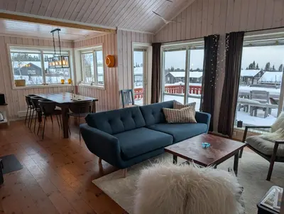 a living room with a blue couch and a table at Håvi Solsiden 11C in Trysil