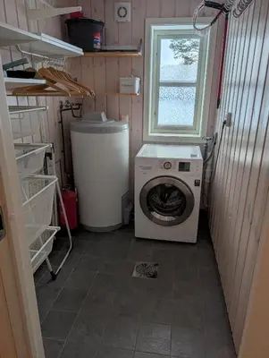 a laundry room with a washing machine and a window at Håvi Solsiden 11C in Trysil