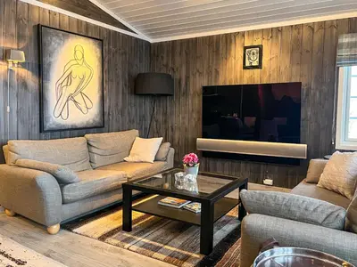 a living room with a couch and a table at Bjønabakkens oase in Beitostøl