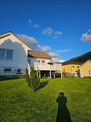 a shadow of a person standing in a yard at Charming and cozy house in Vindafjord in Dørheim