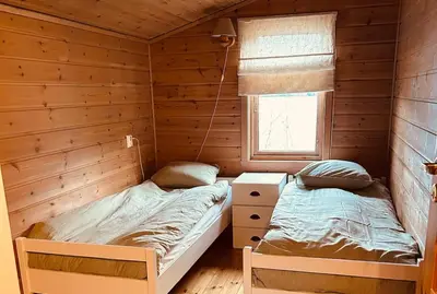 a bedroom with two beds in a log cabin at Look at this view! 3 BR house overlooking Hardangerfjorden in Kvam