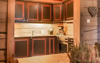 a kitchen with wooden cabinets and a sink and a stove at 2 Bedroom Gorgeous Apartment In Bjorli in Bjorli