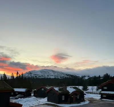 a snow covered mountain in the distance with a sunset at Loft Apartment With Ski Access In Trysil in Trysil