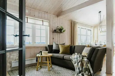 a living room with a couch and some windows at Cabin With Panoramic Views Of Jotunheimen in Gålå