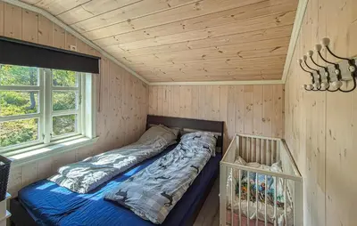 a bed in a room with a wooden ceiling at Cosy Cabin With Jacuzzi Right By The Ski Slope in Norheimsund