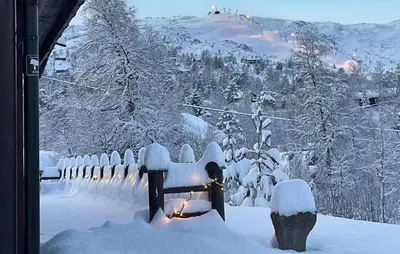 a fence covered in snow with a candle in it at Cosy Cabin With Jacuzzi Right By The Ski Slope in Norheimsund