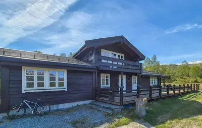 a house with a bike parked in front of it at Cosy Cabin With Jacuzzi Right By The Ski Slope in Norheimsund